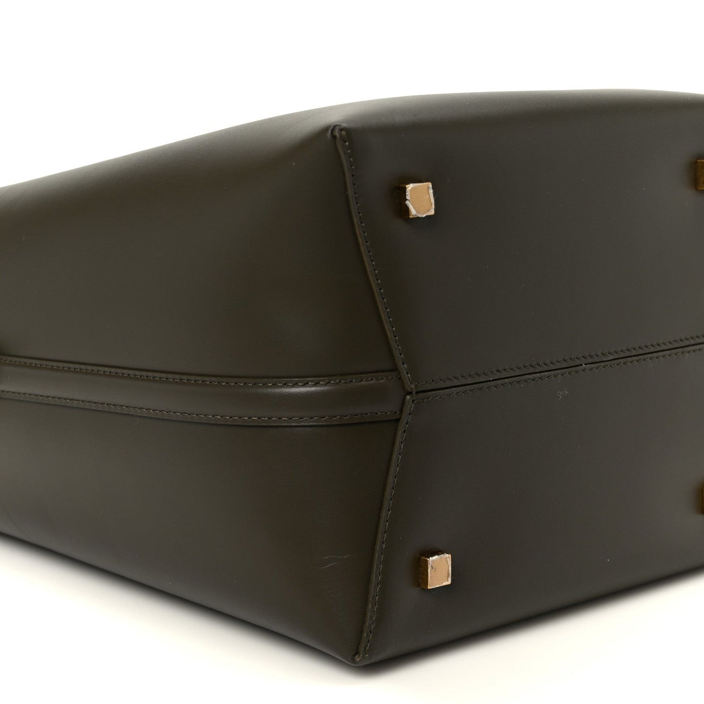 Saint Laurent bucket bag bottom corner view in deep musk leather with gold studs.