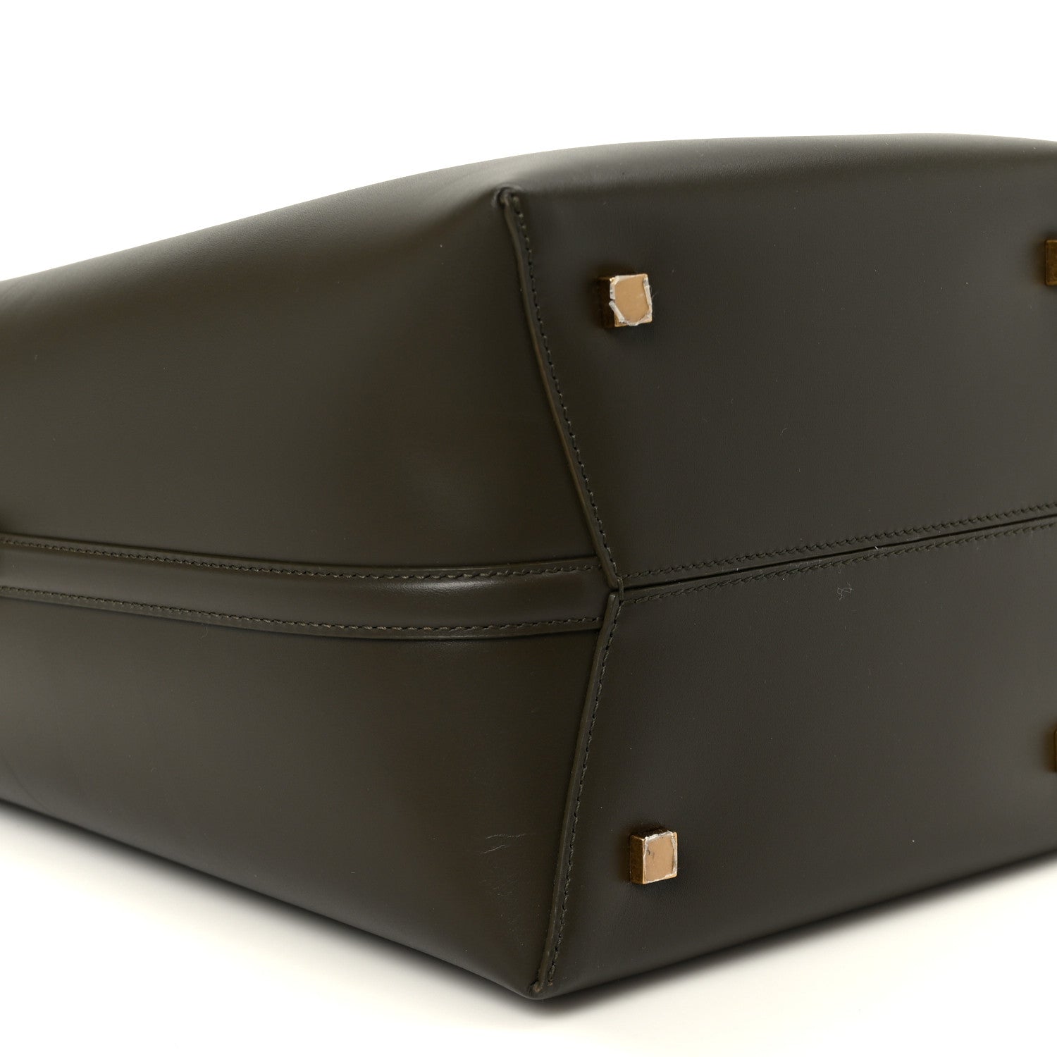 Saint Laurent bucket bag bottom corner view in deep musk leather with gold studs.