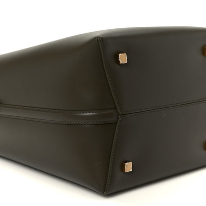 Saint Laurent bucket bag bottom corner view in deep musk leather with gold studs.