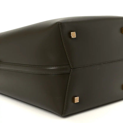 Saint Laurent bucket bag bottom corner view in deep musk leather with gold studs.