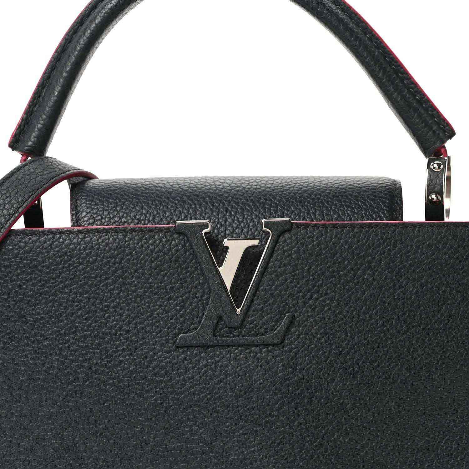 Louis Vuitton Capucines PM leather bag front close-up, dark blue with LV emblem and fuchsia piping