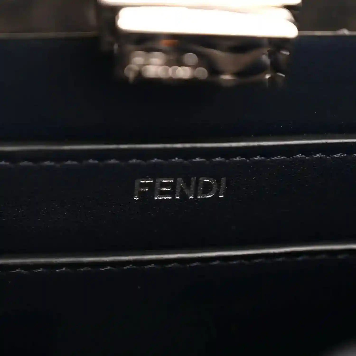 FENDI logo on dark nappa leather satchel, silver-tone rectangular plaque