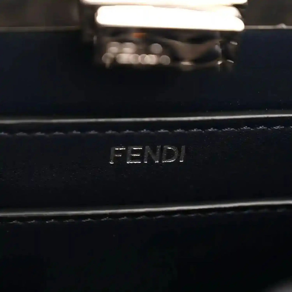 FENDI logo on dark nappa leather satchel, silver-tone rectangular plaque