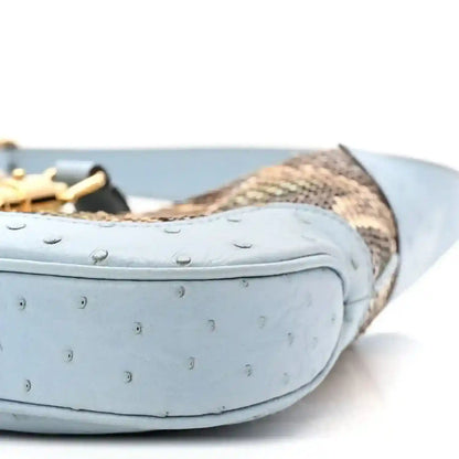 Hobo bag bottom edge close-up with light blue leather and snakeskin trim