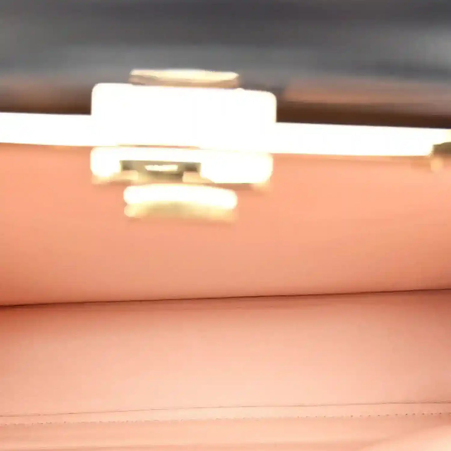 Black satchel interior view with gold-tone clasp hardware