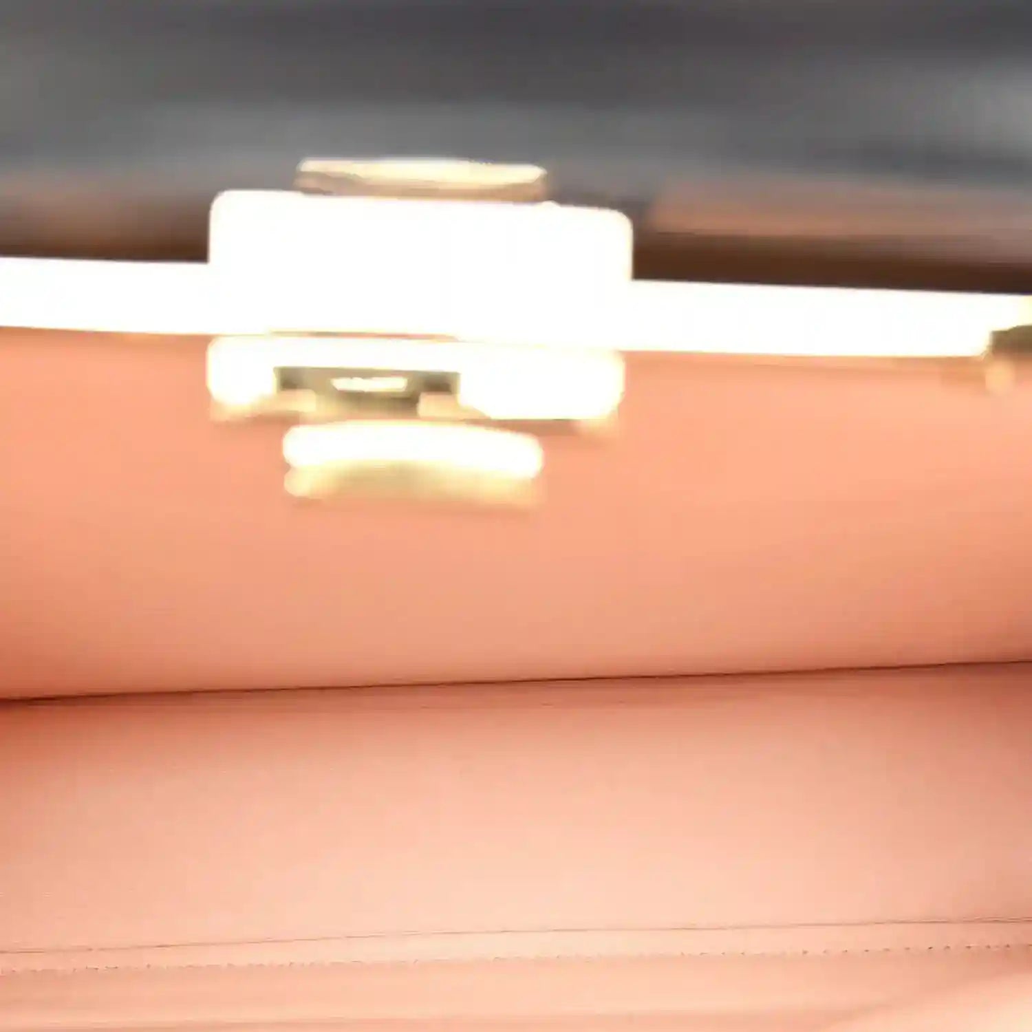 Black satchel interior view with gold-tone clasp hardware