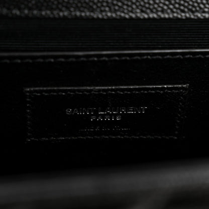 Black leather satchel label with embossed SAINT LAURENT text