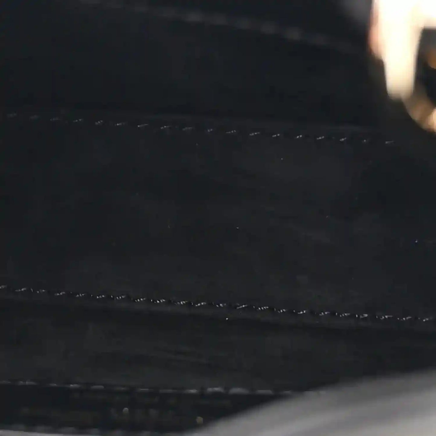 Black leather handbag exterior with quilted stitching detail