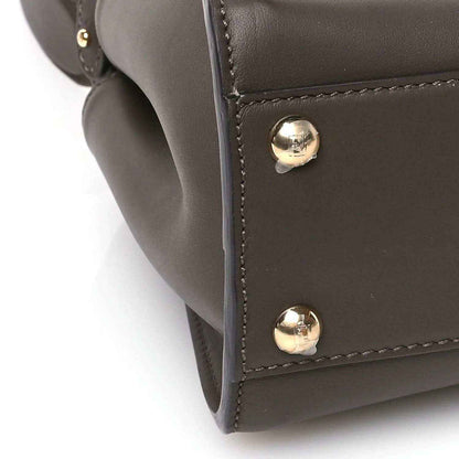 Mini satchel corner in dark brown leather with two gold snap studs.