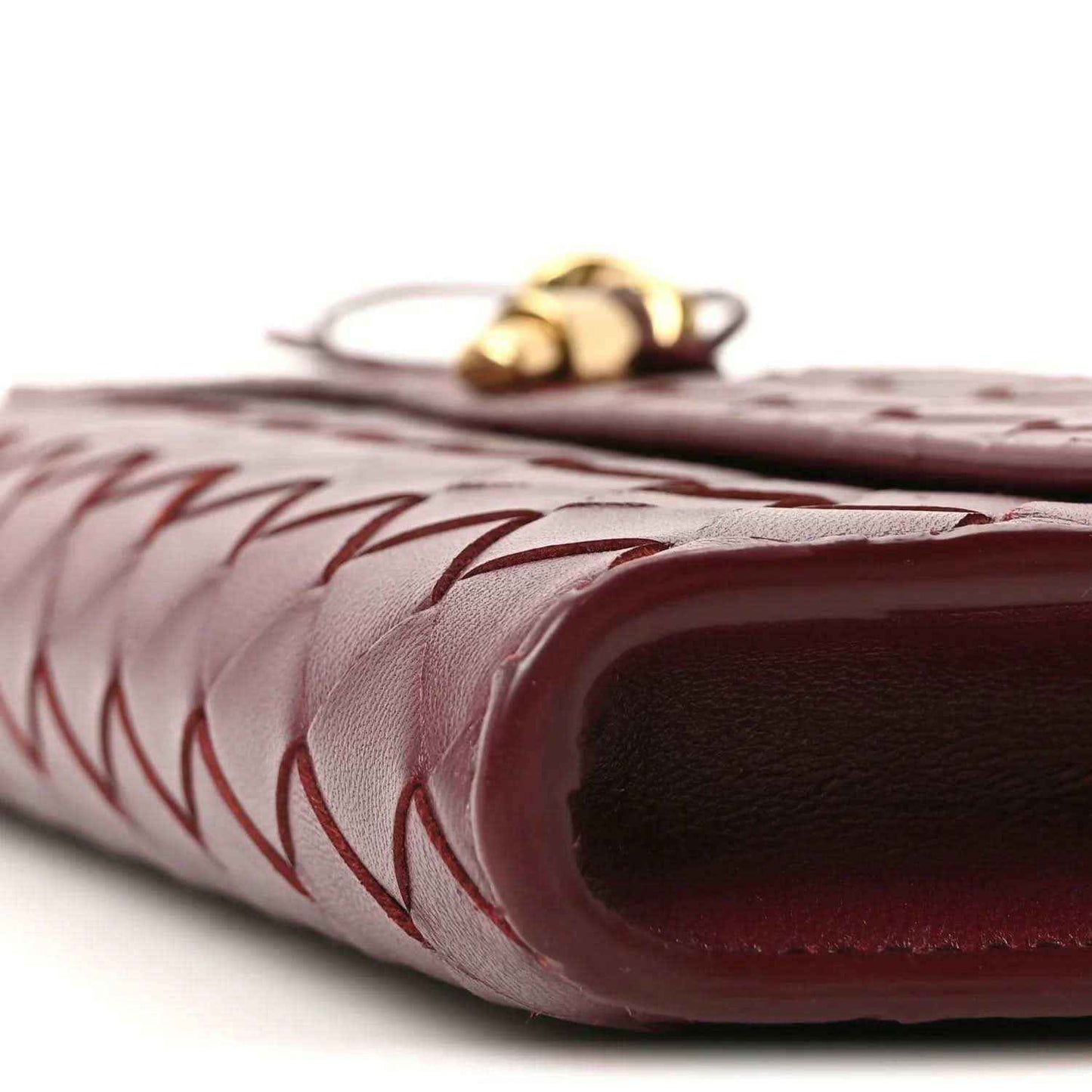 Bottega Veneta long clutch end detail in barolo with gold hardware, close-up