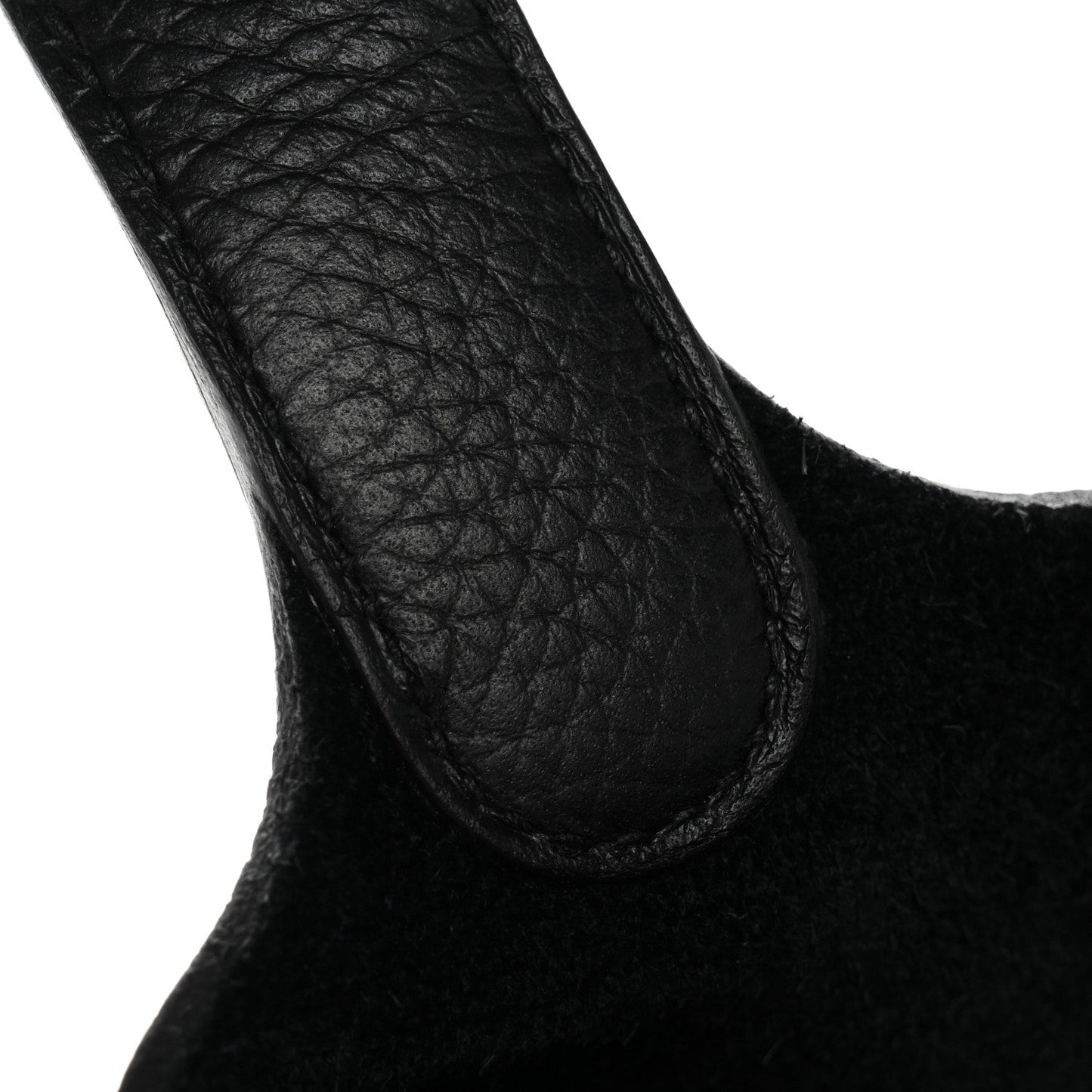 Black pebbled leather tote handle close-up, curved opening