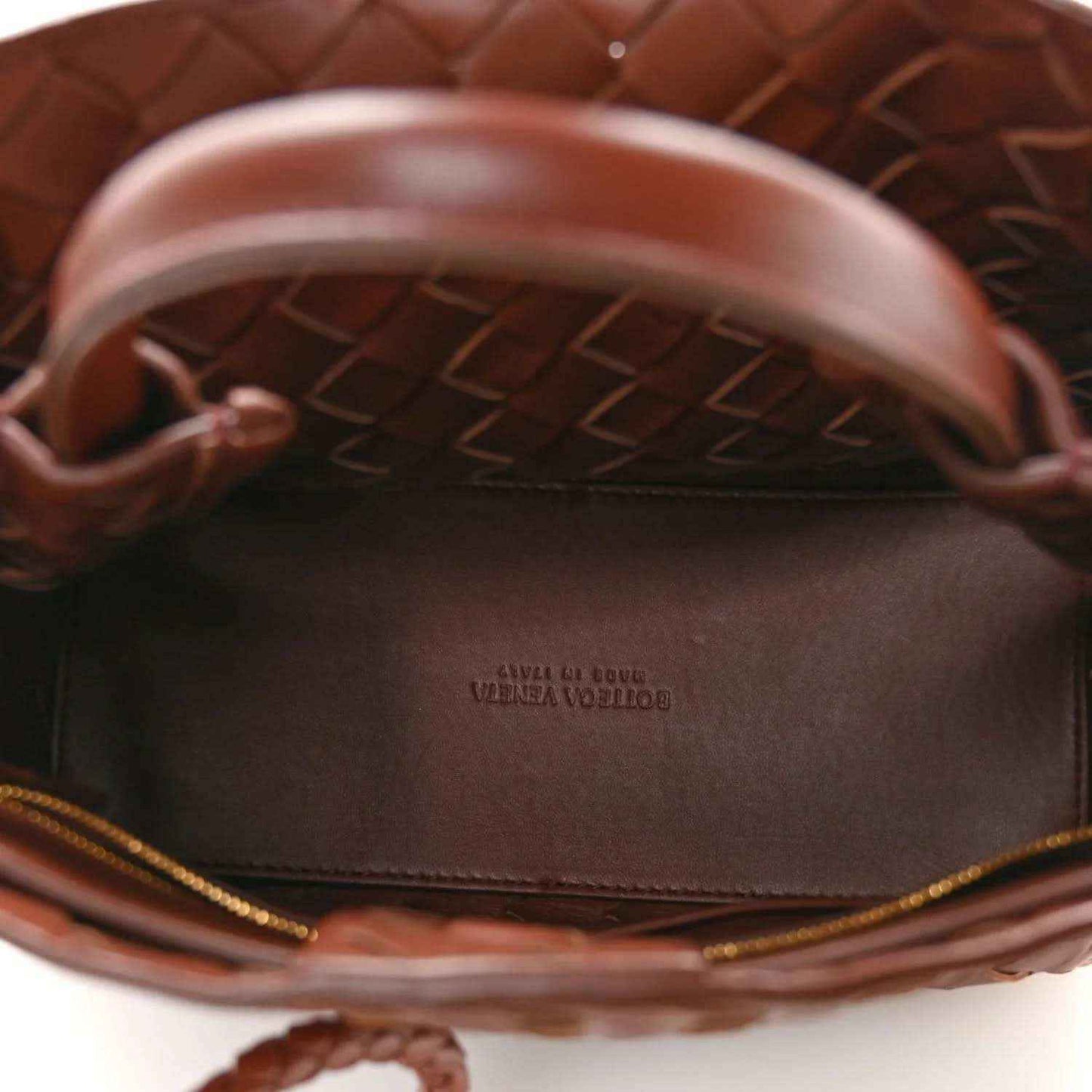 Small leather bag interior with logo stamp on the lining and braided trim