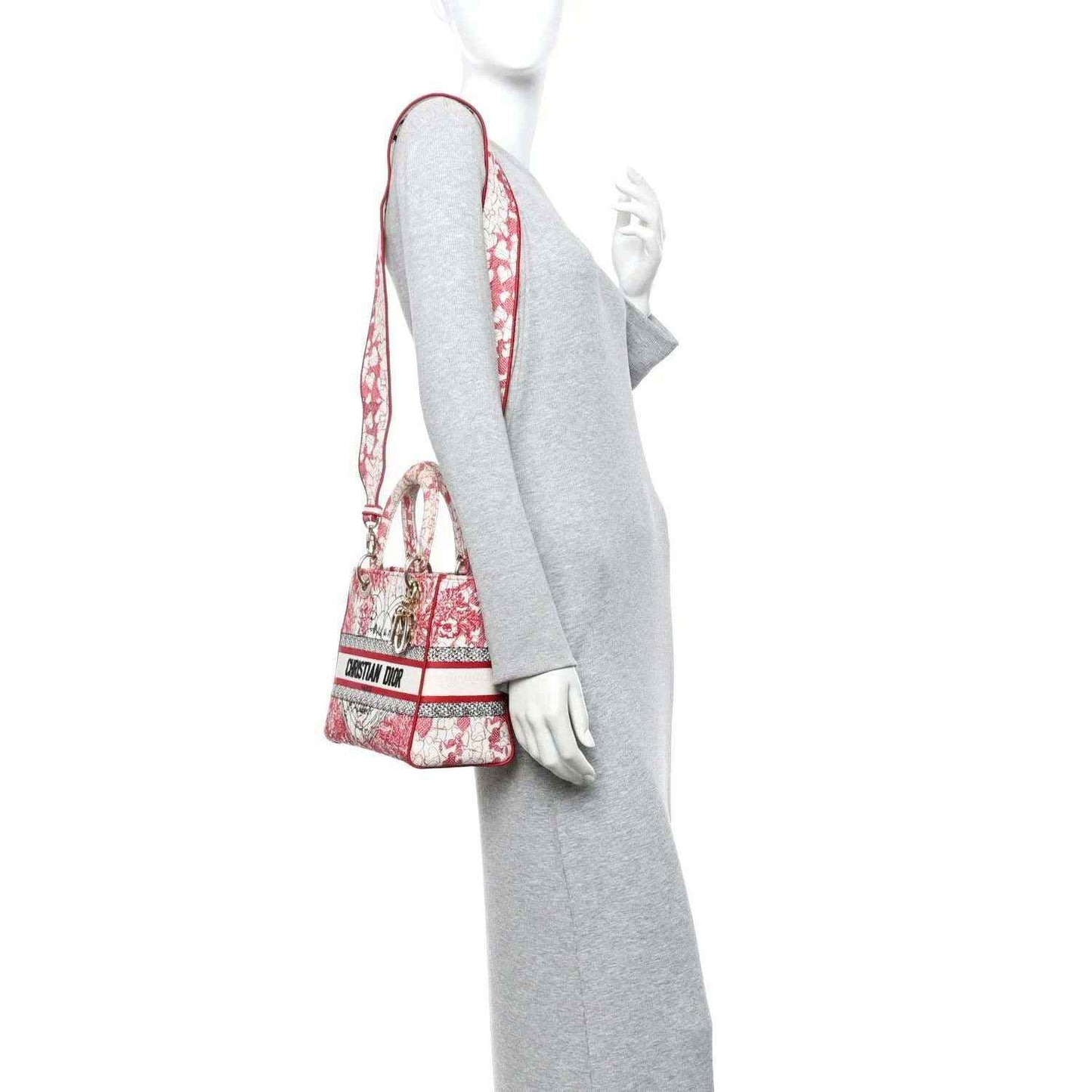 Red and white embroidered handbag with long strap, worn on a mannequin