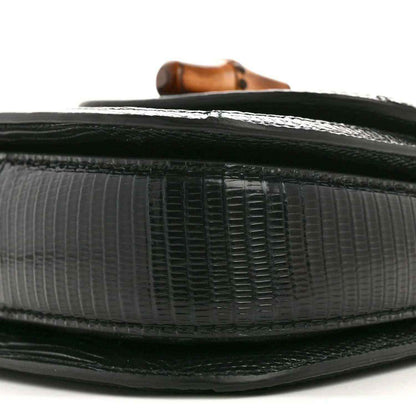 Gucci mini top handle bag side edge close-up, black embossed leather texture and trim