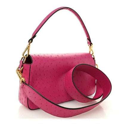 Pink ostrich leather baguette handbag with top handle, shoulder strap, and gold clasp