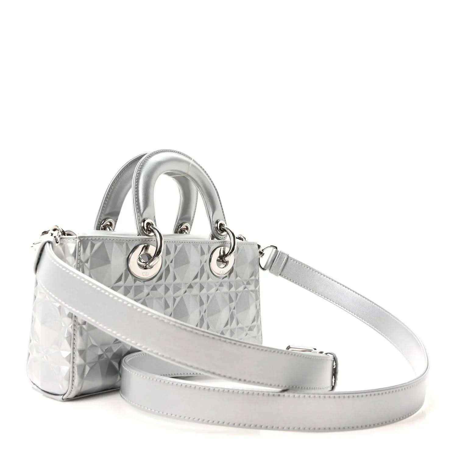 Small metallic silver handbag with geometric canage texture, top handles, and crossbody strap.