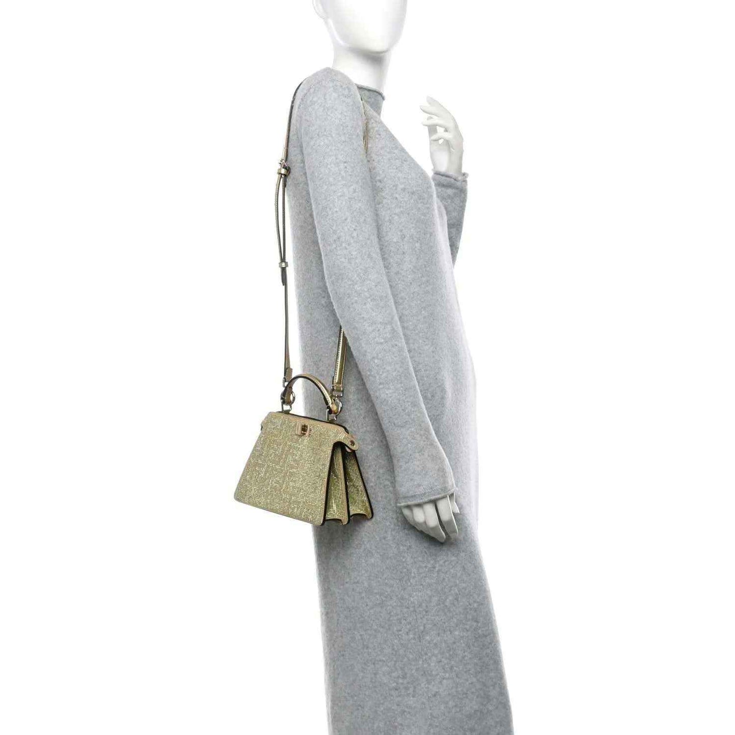 Small gold crystal satchel with top handle and short strap charm on a model