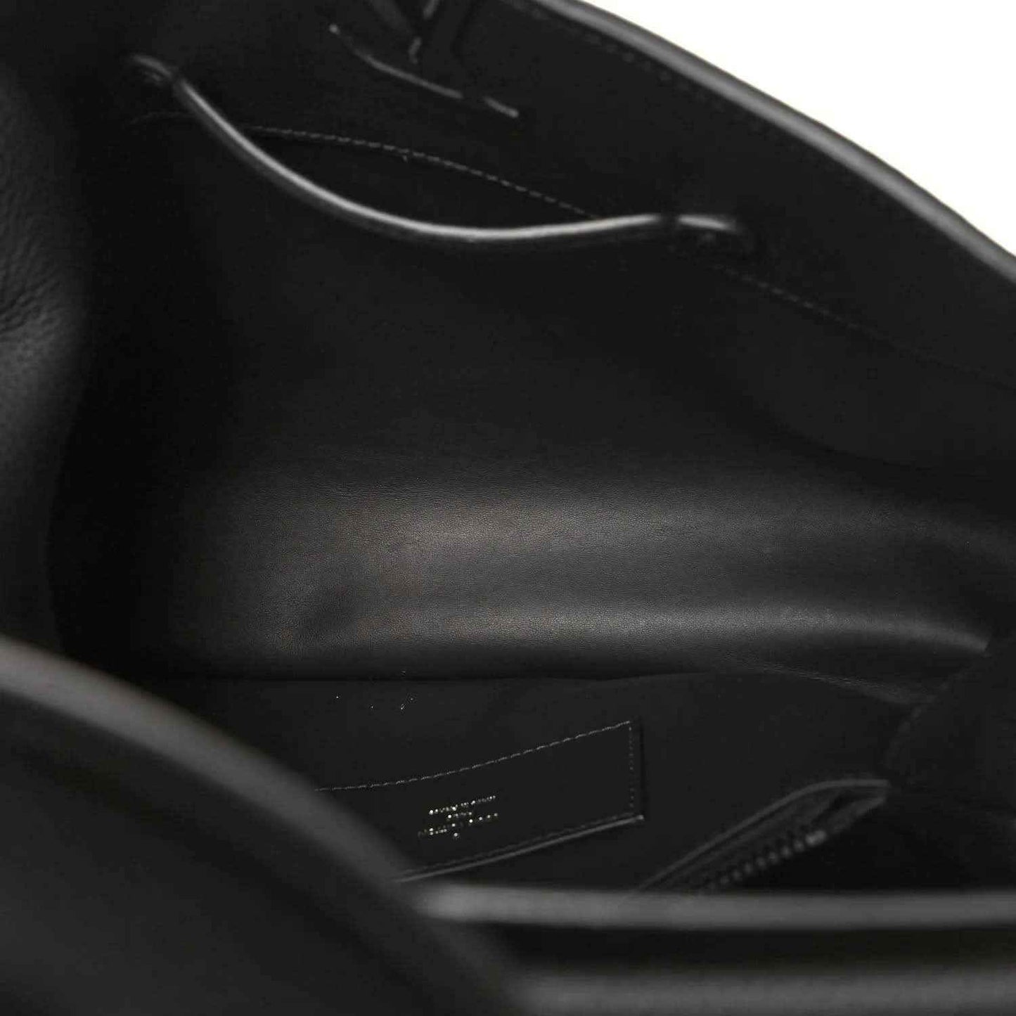 Black leather handbag interior view with zipper and stitched lining