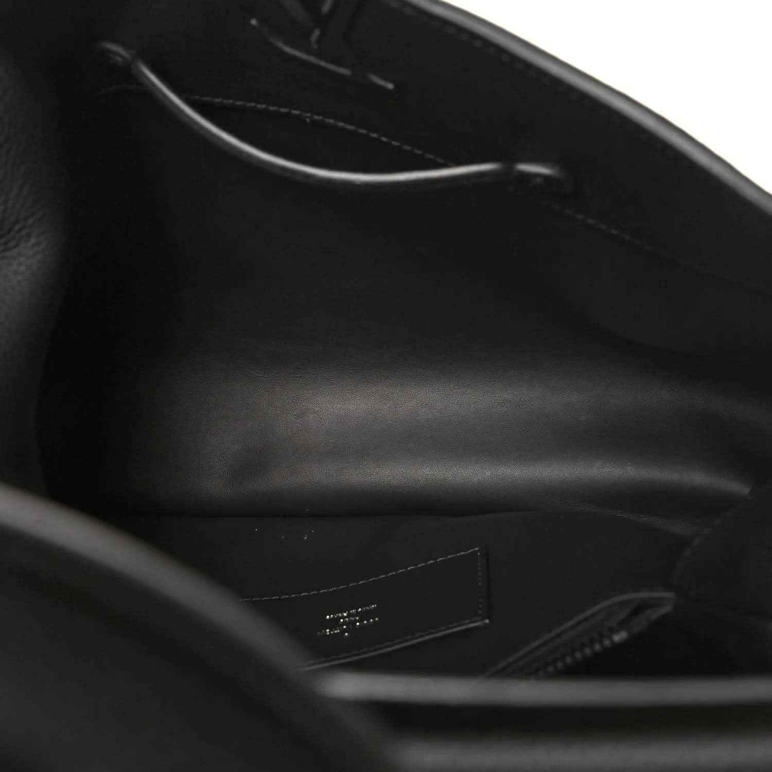 Black leather handbag interior view with zipper and stitched lining