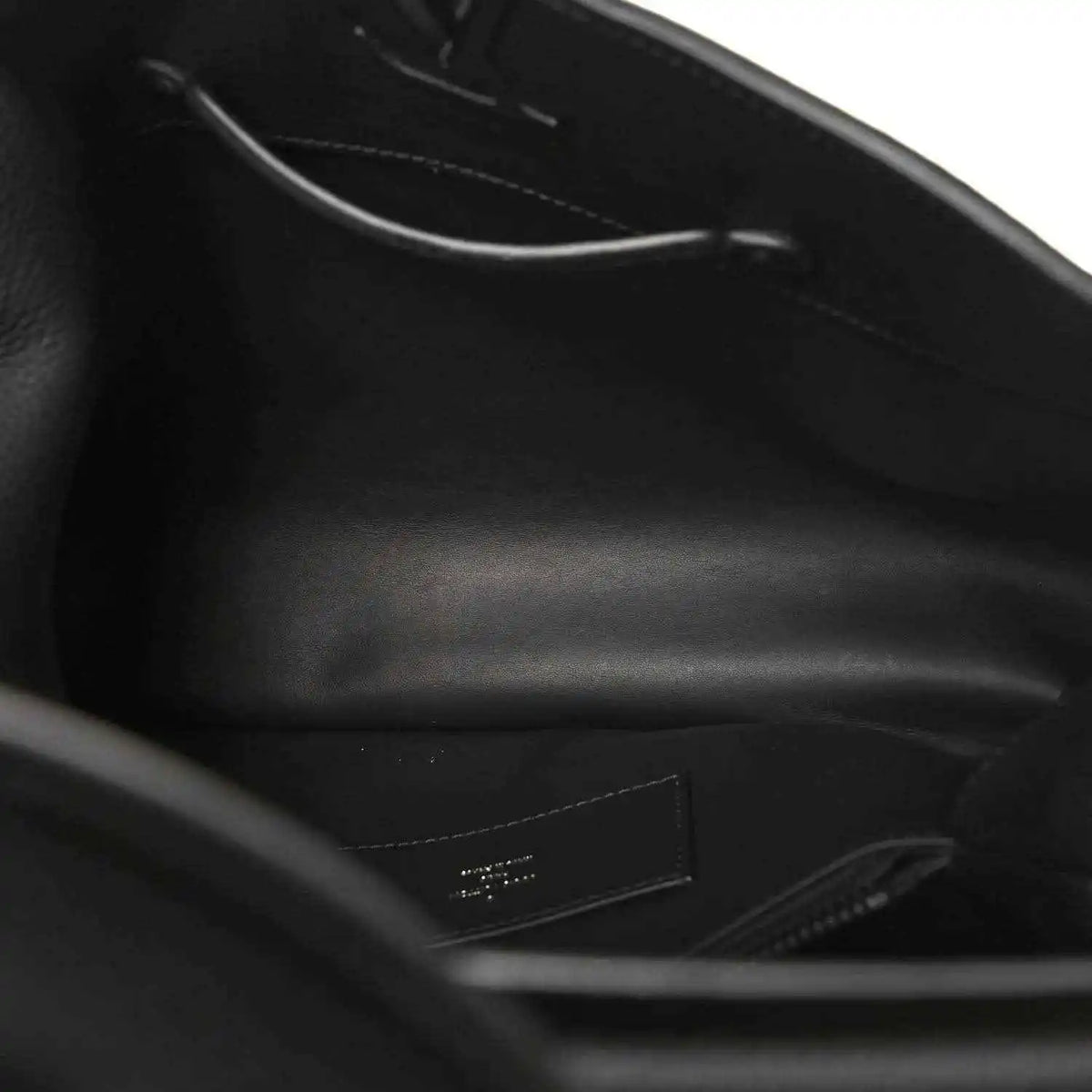 Black leather handbag interior view with zipper and stitched lining