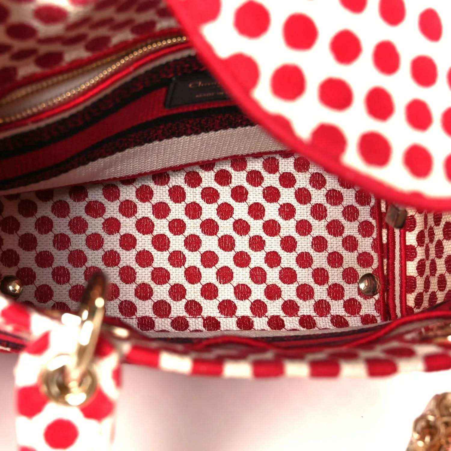 Polka dot canvas bag opening with gold zipper and red fabric trim