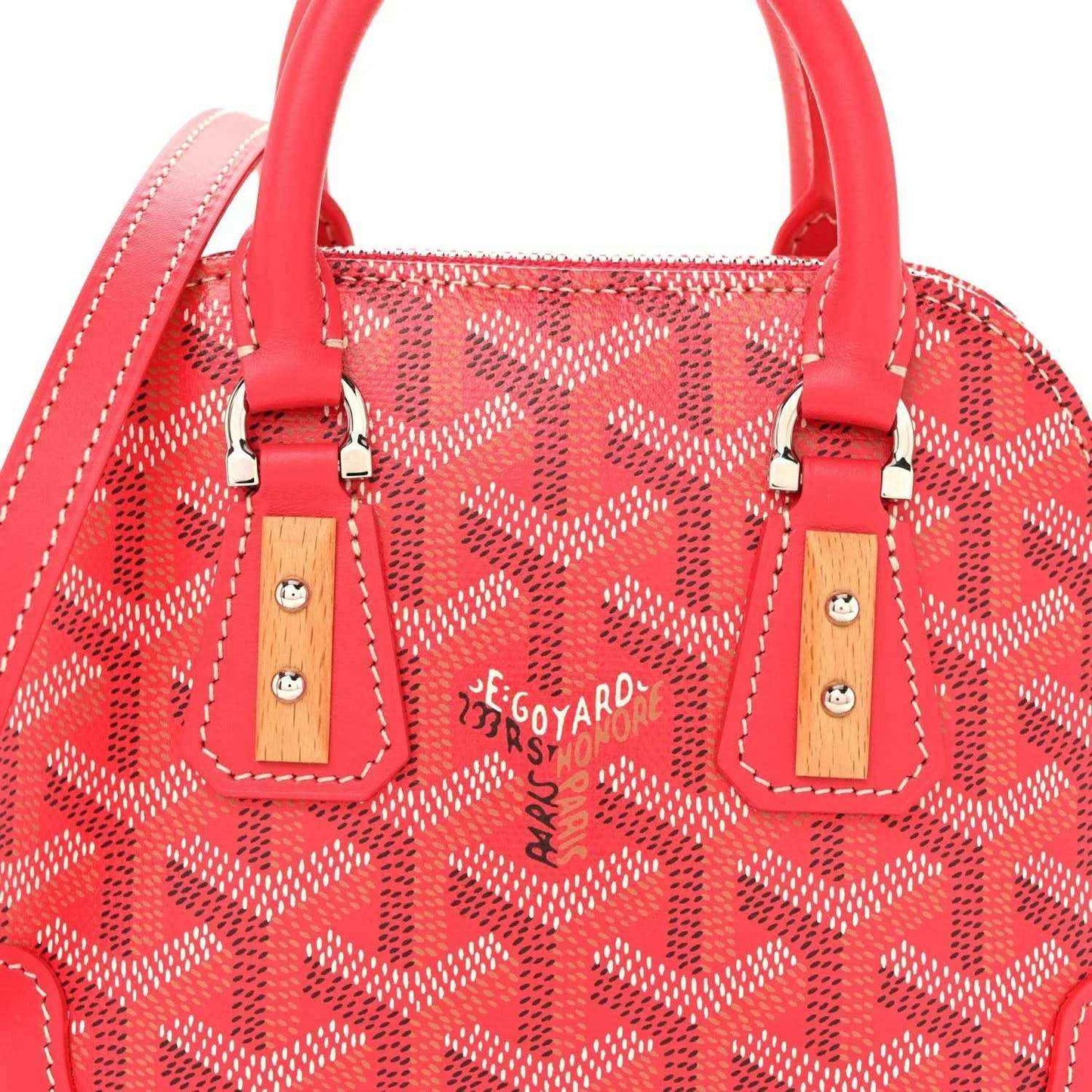 Fuchsia mini handbag top view with red handles, patterned body, and silver hardware