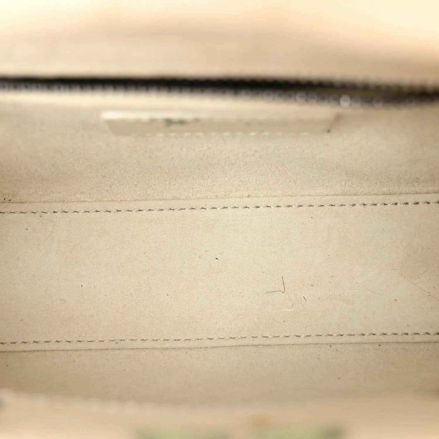 Mini Lady Dior bag close-up of stitched leather seam in white