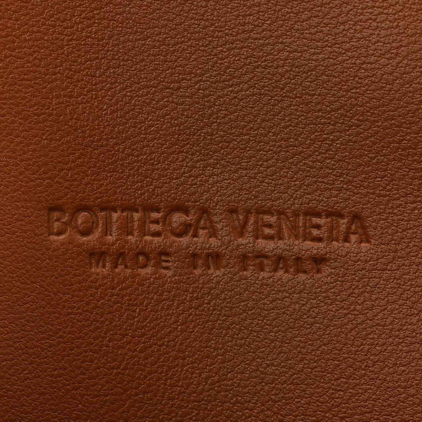 Bottega Veneta embossed logo on amber-brown suede clutch