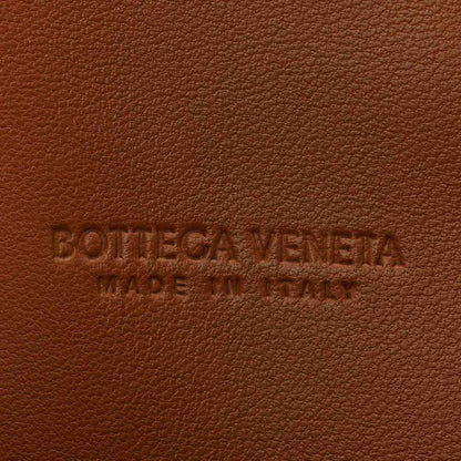 Bottega Veneta embossed logo on amber-brown suede clutch