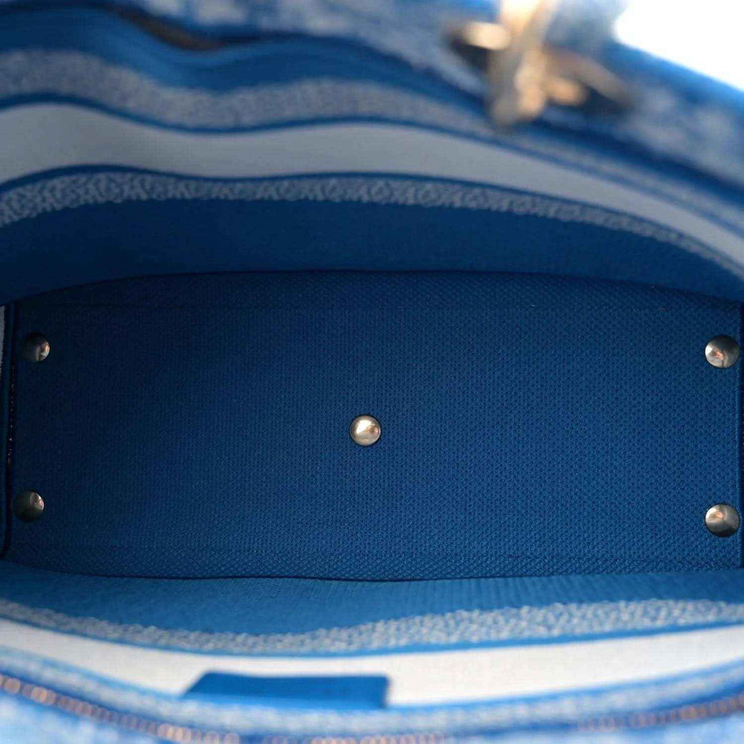 Blue fabric interior lining with metal snap button details inside the bag.
