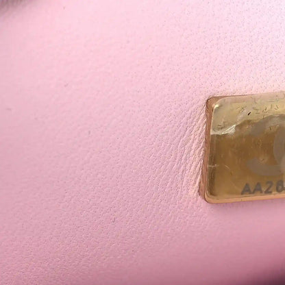 Chanel Mini 22 handbag leather flap corner detail with gold-toned logo tag.