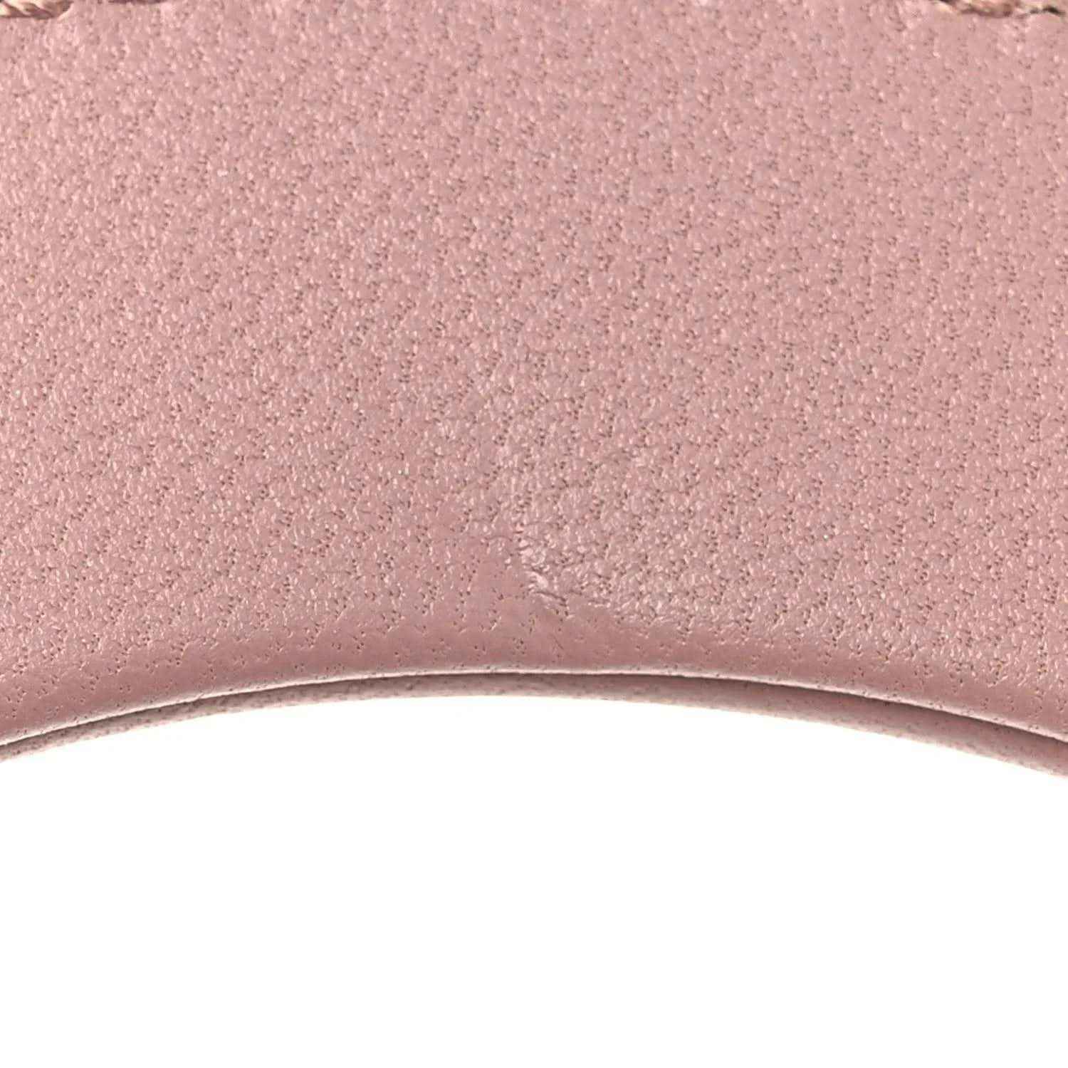 Mini Lady Dior lambskin handbag, pink leather texture close-up with fine grain