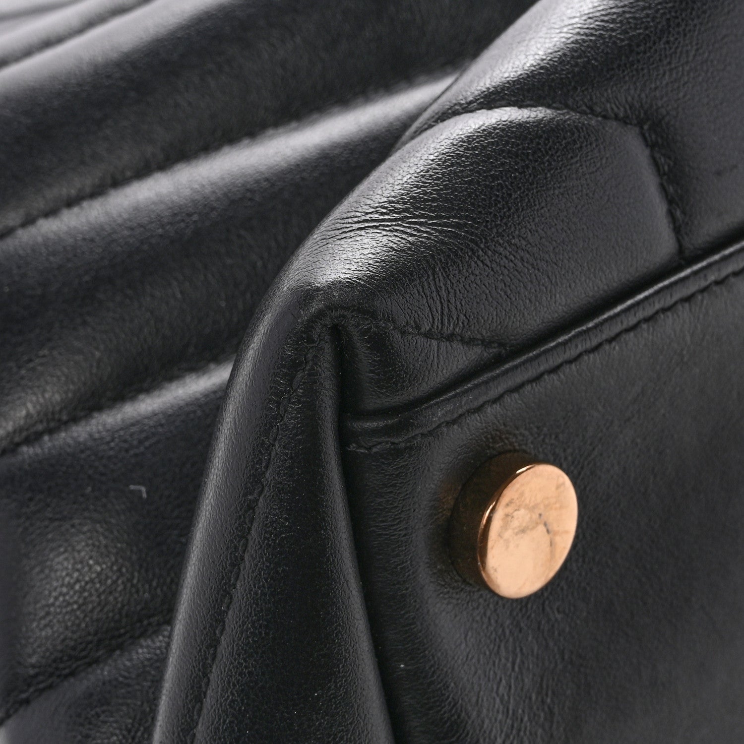 Black leather satchel corner with gold-tone snap button