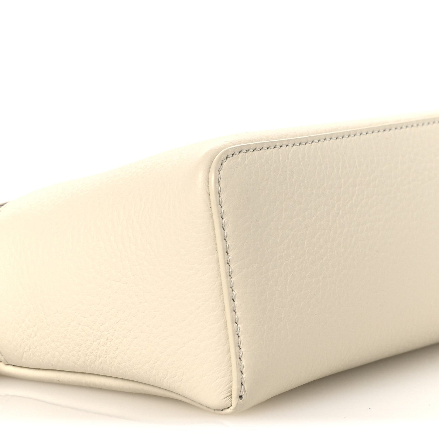 White grained calfskin pouch side with stitched panel seam, close-up
