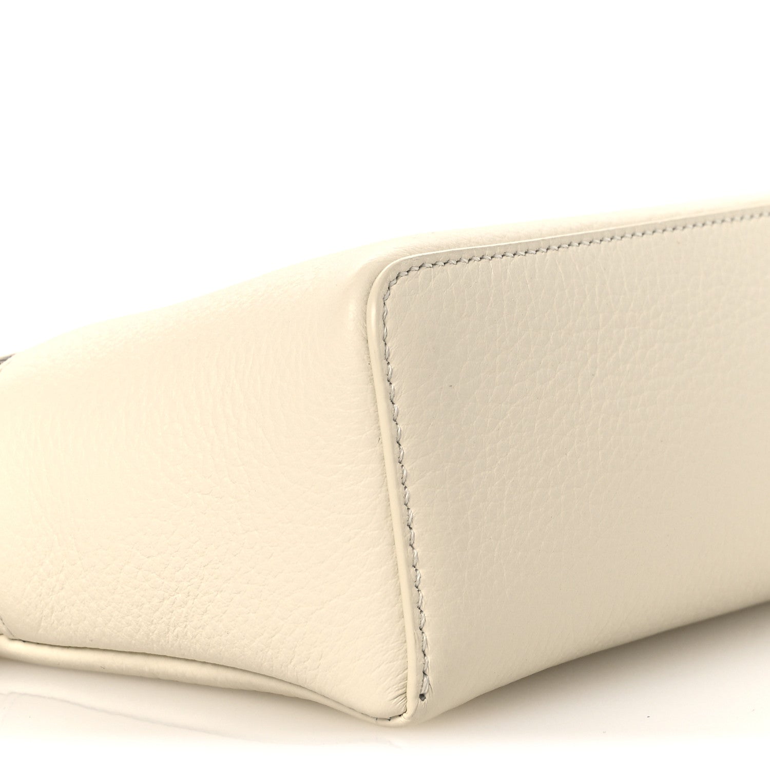 White grained calfskin pouch side with stitched panel seam, close-up