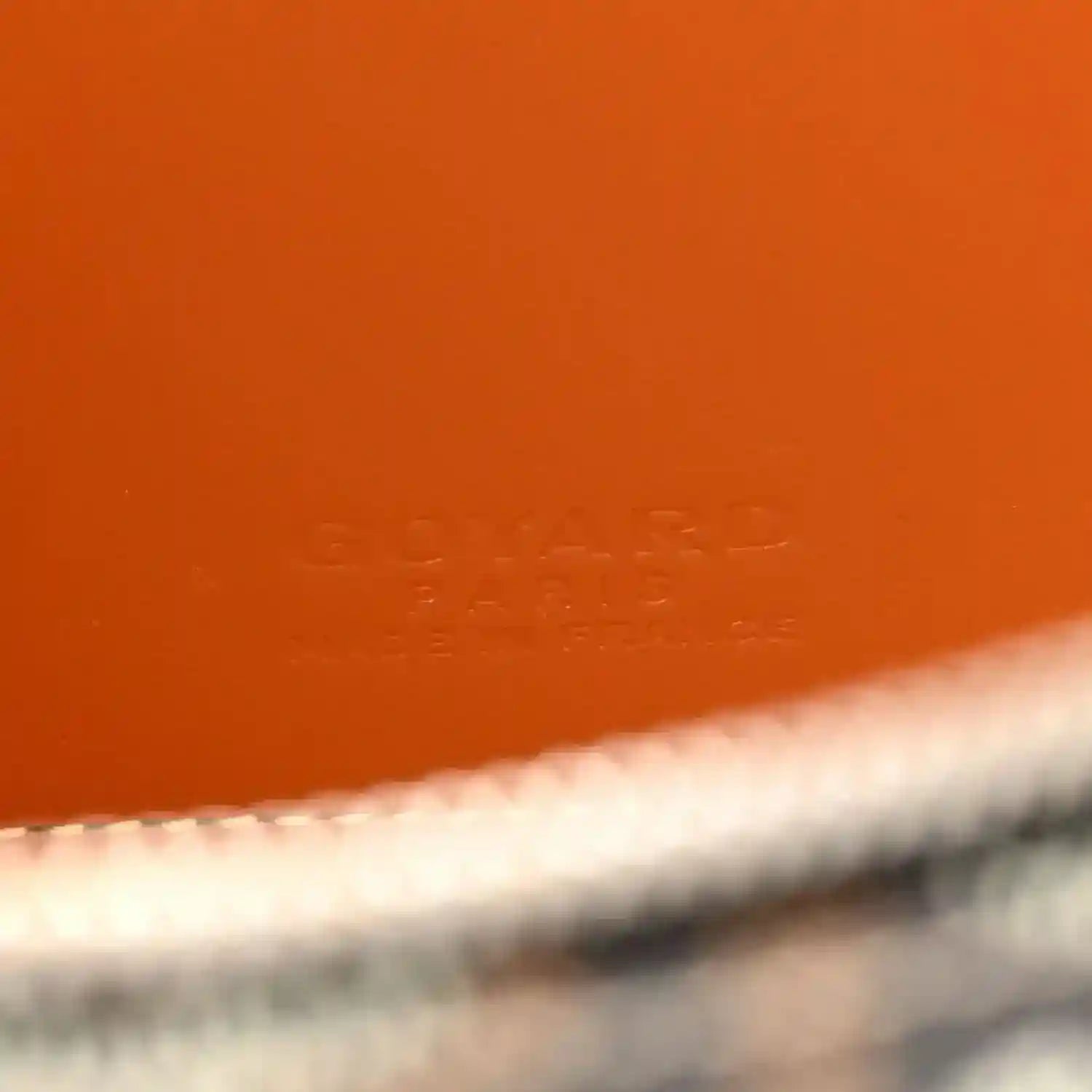 Orange leather interior panel with stamped logo on mini vanity case