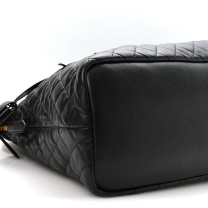 Black quilted leather travel bag with smooth end panel and shoulder strap