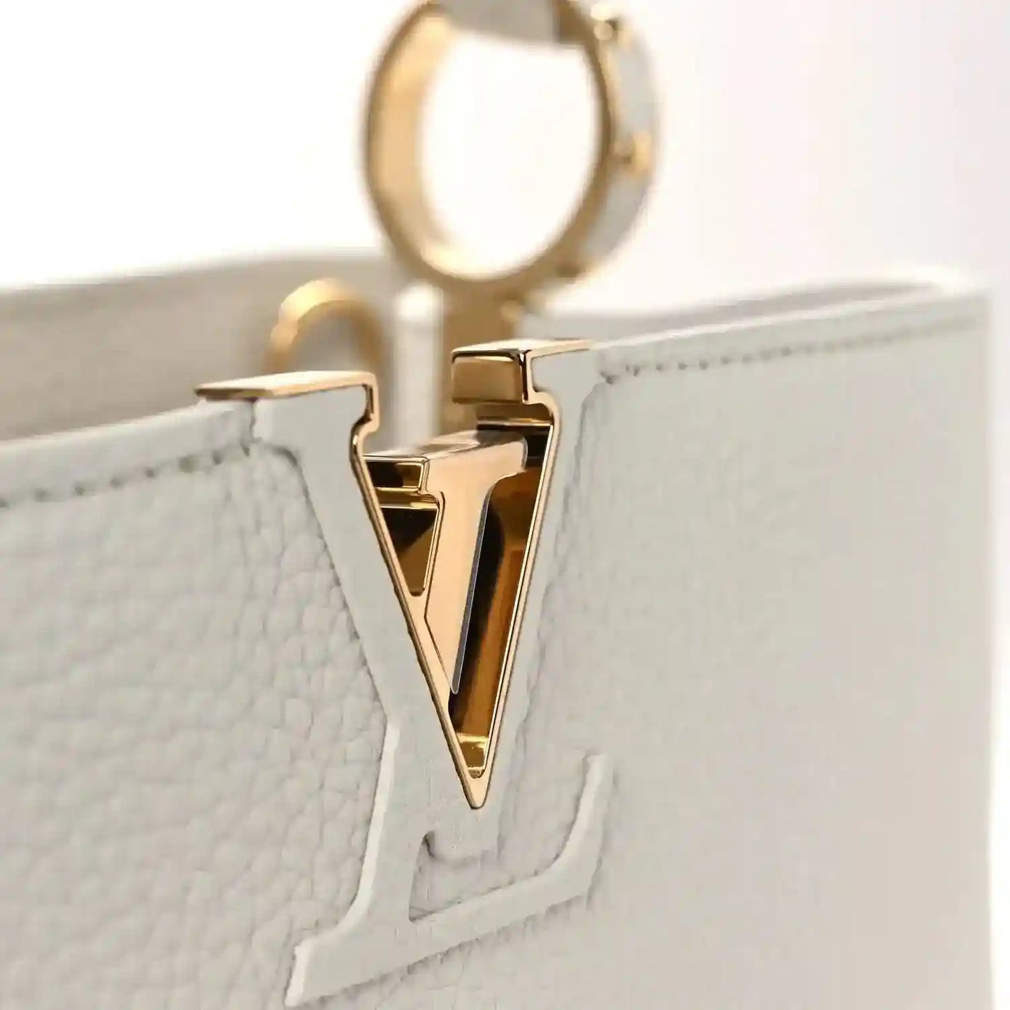 Louis Vuitton Capucines BB leather handbag close-up of gold-tone LV V logo