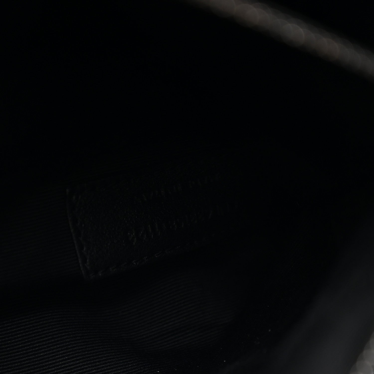 Black satchel interior lining with subtle texture and stitched pocket seam