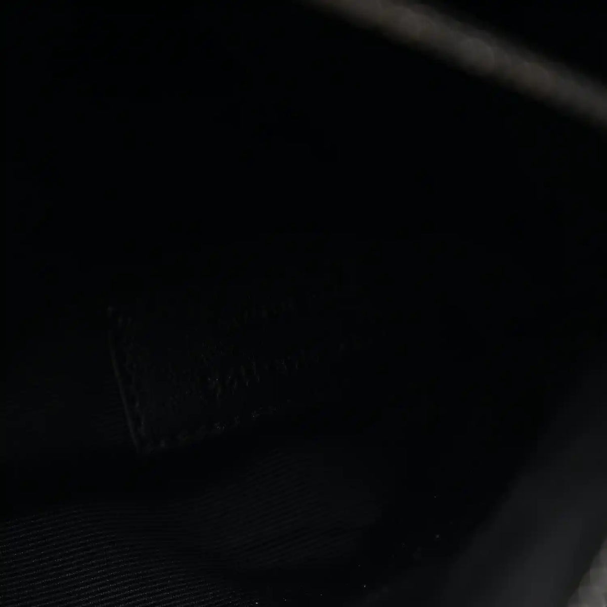 Black satchel interior lining with subtle texture and stitched pocket seam