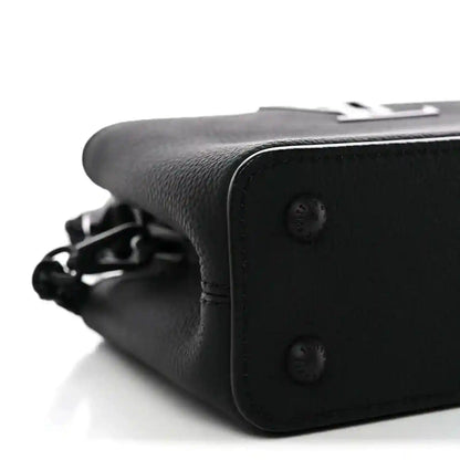 Black mini handbag side close-up with snap buttons and chain strap