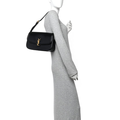 Saint Laurent black leather shoulder bag with gold YSL monogram on a model