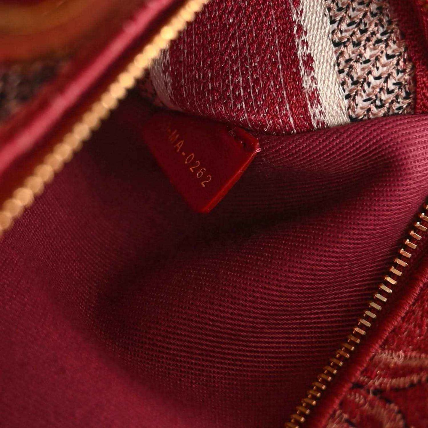Red fabric lining inside handbag with zipper track and small interior tag