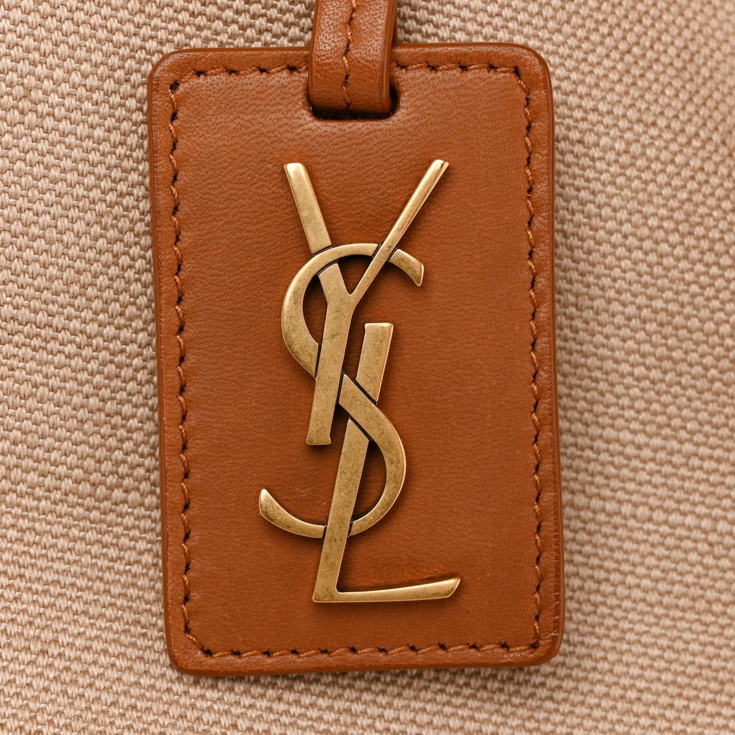 Leather-front tote tag with YSL gold logo and brown edge stitching