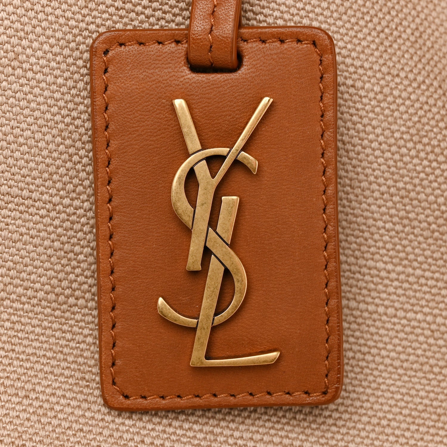 Leather-front tote tag with YSL gold logo and brown edge stitching