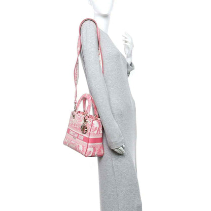 Pink mini tote bag on model’s side view with shoulder strap and gold hardware