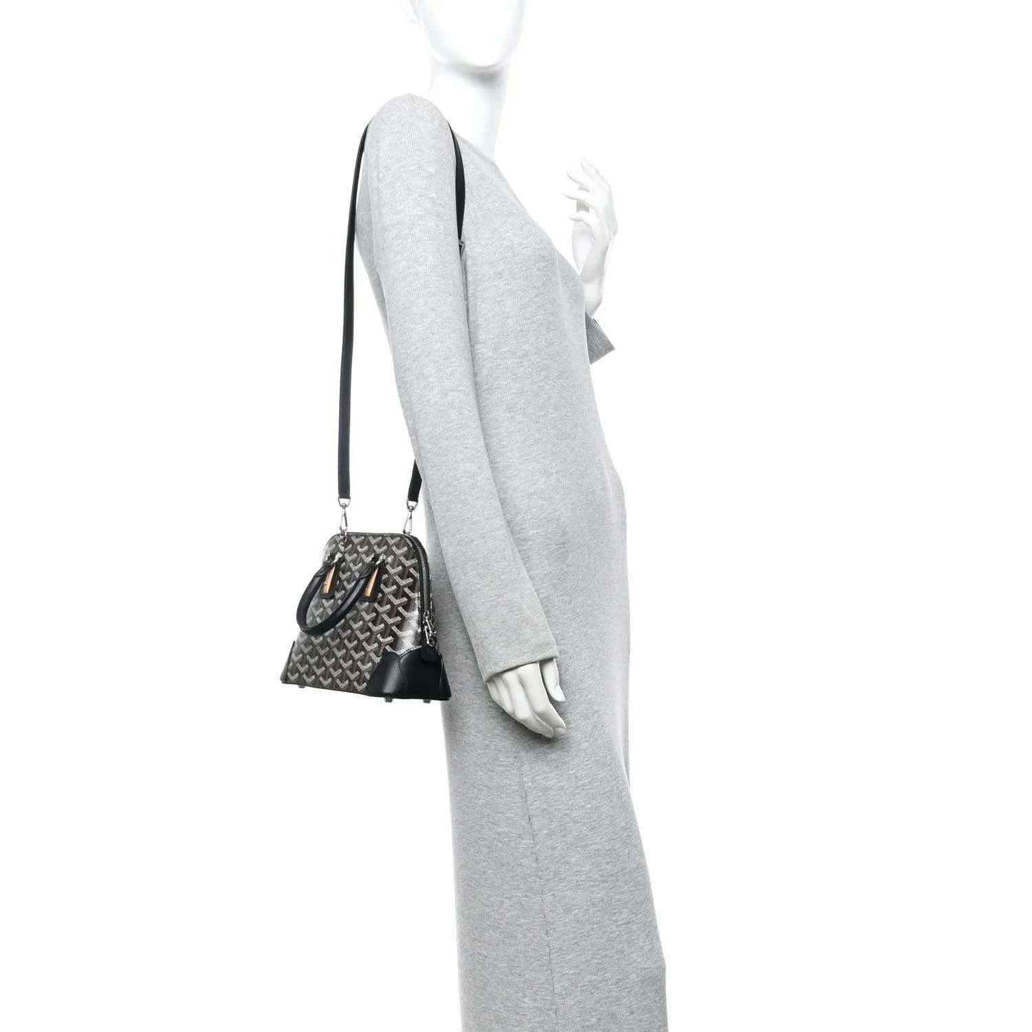 Mini crossbody handbag with monogram canvas and black leather trim, worn with strap