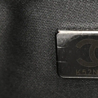 Chanel leather close-up with embossed stamp and metal tag on dark caviar surface
