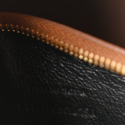 Brown leather hobo bag detail with gold-tone zipper teeth