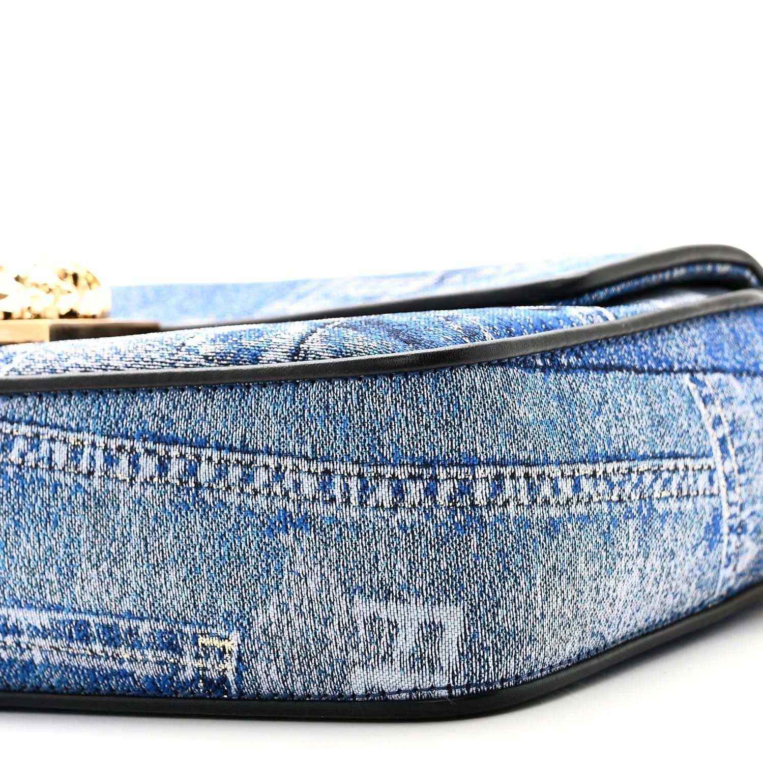Blue denim baguette bag close-up of black-trimmed edge and patchwork stitching